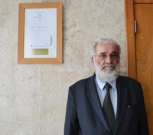 O Corregedor-Geral da Justiça, Des. Valmir de Oliveira Silva, ao lado do quadro da capa do primeiro processo administrativo eletrônico do TJRJ