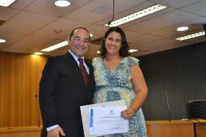 Miguel Braga entrega o certificado de participação a regente Natália Mota.