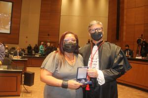 Ingrid Lima dos Santos Pádua recebe a homenagem póstuma ao ascensorista Wagner Xavier de Queiroz  das mãos do presidente do TJRJ, desembargador Henrique Carlos de Andrade Figueira