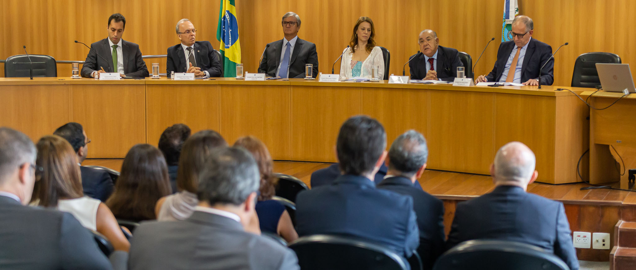 Imagem do auditório José Navega Cretton com plateia de costas e ao fundo mesa composta, da esquerda para direita, por: Anderson de Paiva Gabriel, Ricardo Rodrigues Cardozo; Henrique Carlos de Andrade Figueira; Eunice Bitencourt Haddad; Jorge Mussi; e Marcus Henrique Pinto Basílio