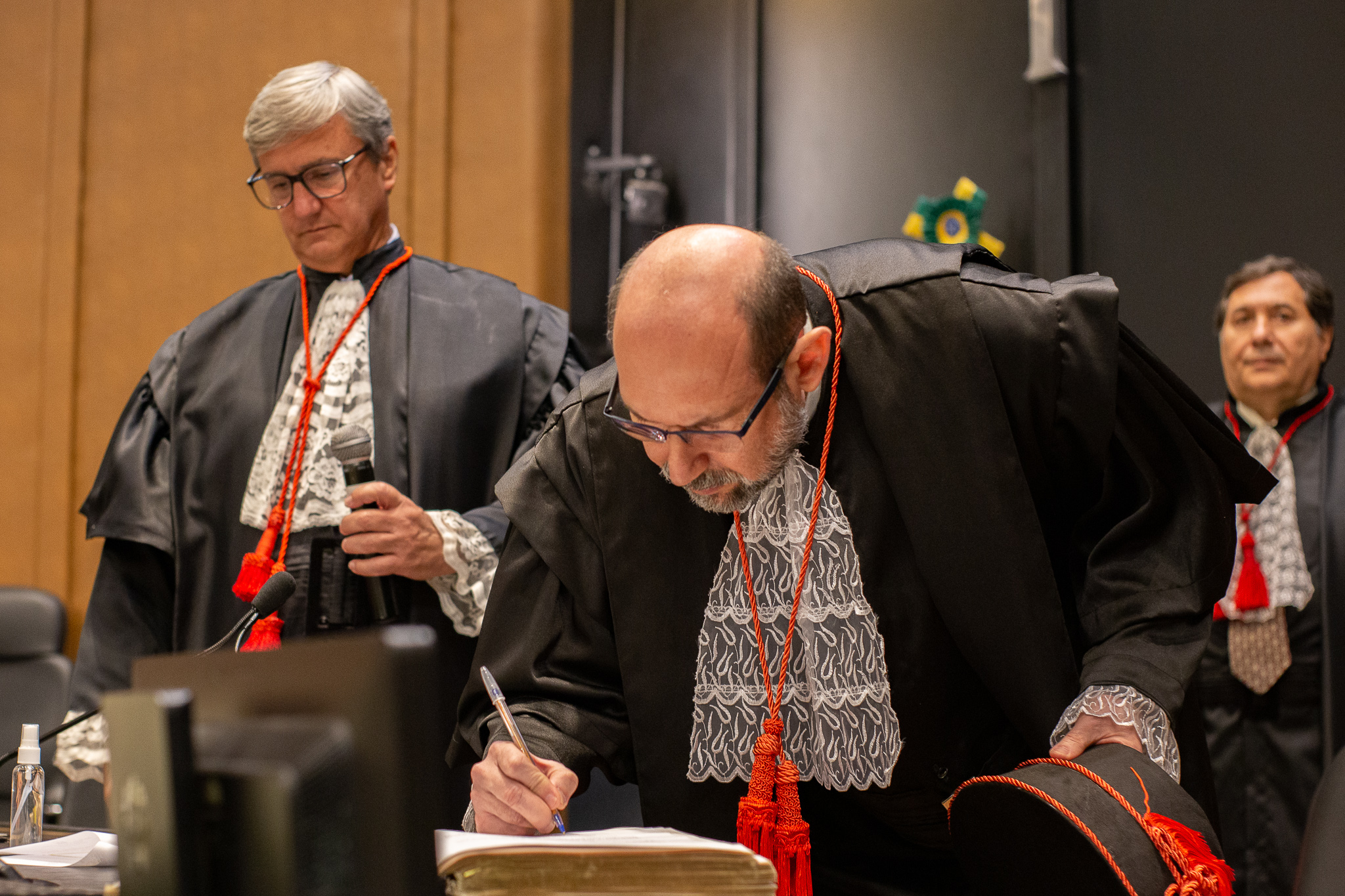 Imagem do desembargador Jean Albert de Souza Saadi assinando termo de posse em cerimônia realizada em sessão do Órgão Especial