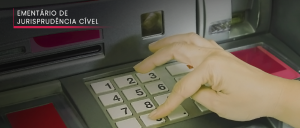 Mão digitando em caixa eletrônico.