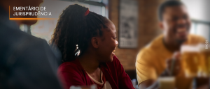 #ParaTodosVerem: Acima, no canto esquerdo, o título “EMENTÁRIO DE JURISPRUDÊNCIA”. Imagem de três pessoas negras sorridentes, sendo, das três, a do meio, mulher, todas interagindo em um restaurante, ao sabor de tulipas de chope.