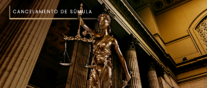 Legenda:#ParaTodosVerem: Acima, no canto esquerdo, o título “CANCELAMENTO DE SÚMULA”. Imagem de salão de tribunal, em tom cobreado, com diversas colunas cilíndricas, e, em primeiro plano e tamanho natural, a escultura da deusa Têmis – a deusa da Justiça.
