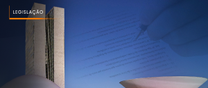 Legenda:#ParaTodosVerem: Acima, no canto esquerdo, o título “LEGISLAÇÃO”. Compondo a imagem, fachada do Palácio do Planalto, ou Palácio do Congresso Nacional, no Distrito Federal (Brasília). À direita, mão esquerda e branca de homem, ao fundo, conferindo, à caneta, documentação por escrito.