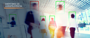 Seis pessoas transitam em local público, sob a mira de câmera para reconhecimento facial.