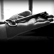 Fotografia em preto e branco de uma chave antiga sobre a palme de uma mão