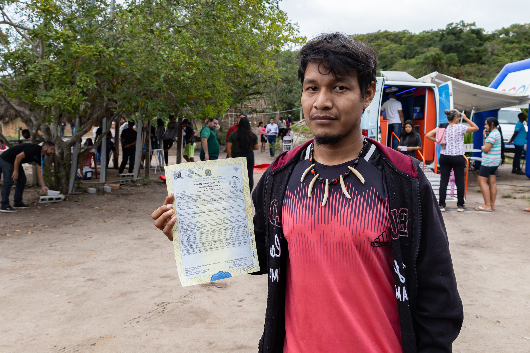 O motorista Denilson Wera recebe sua nova certidão durante a ação 