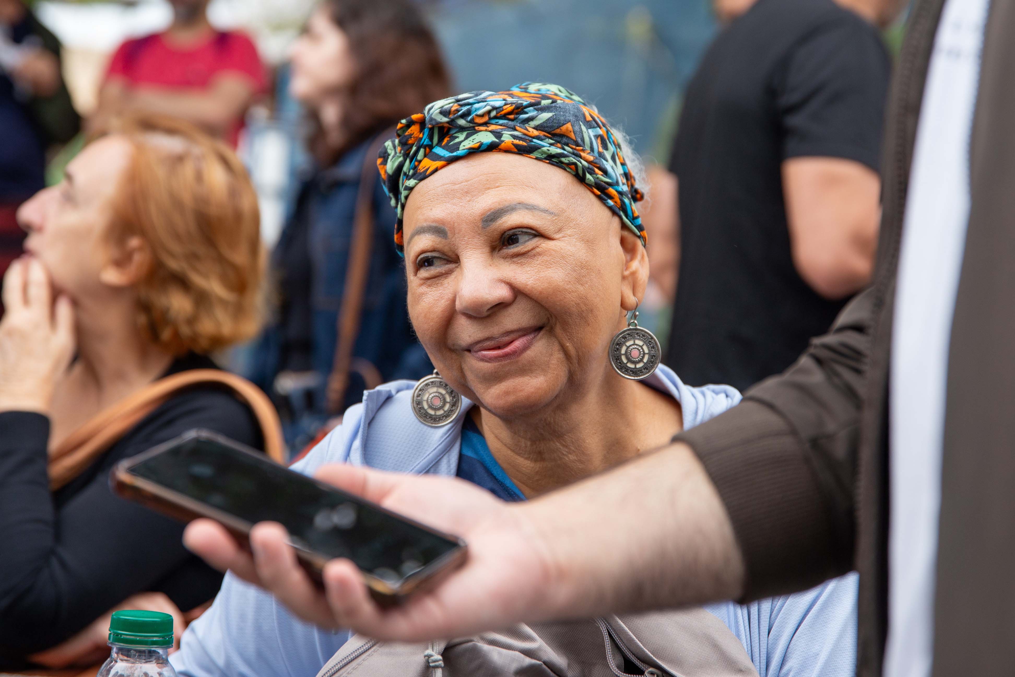 Uma senhora com expressão sorridente durante uma entrevista