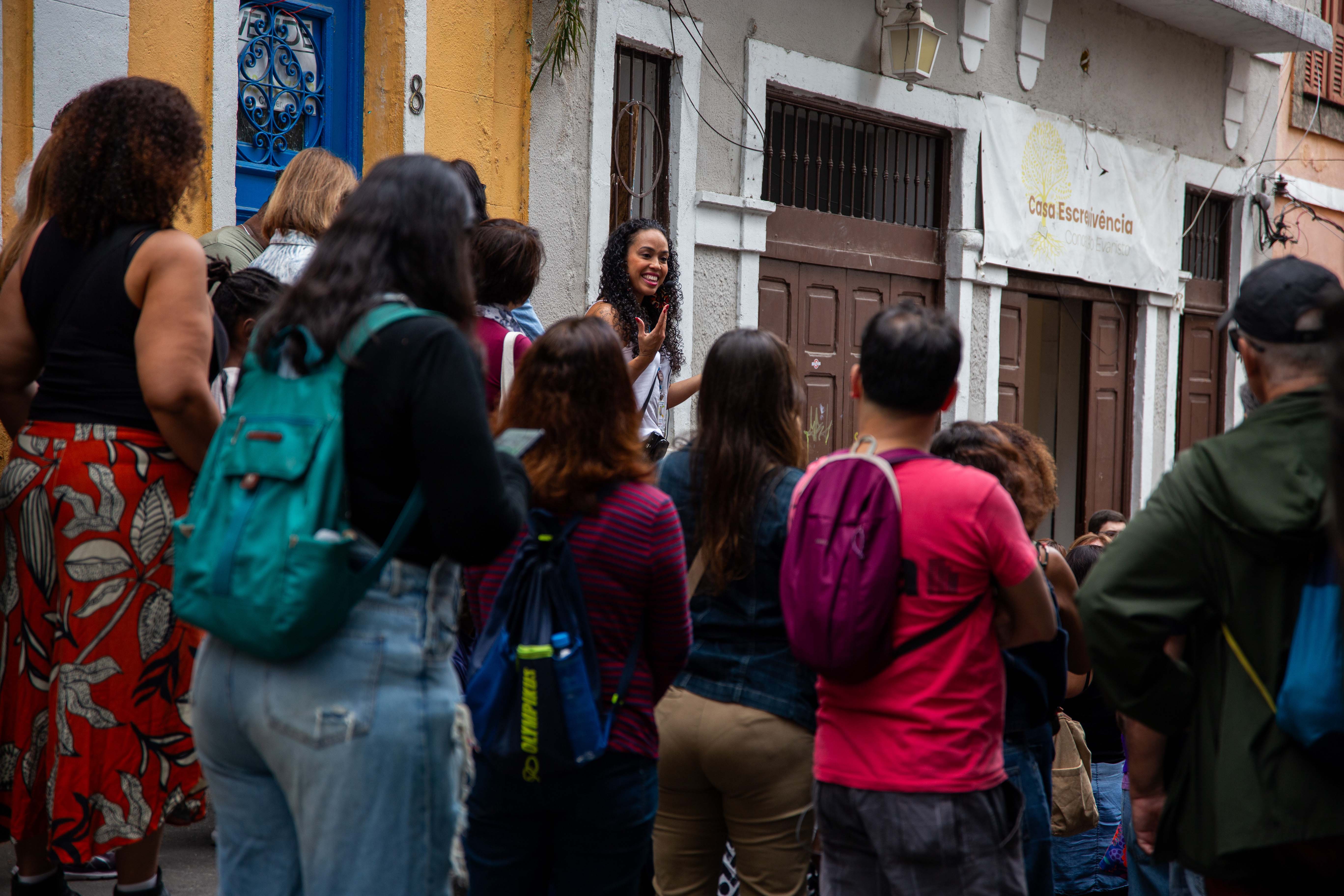 Uma moça aparece ao centro mostrando o local ao restante do grupo.