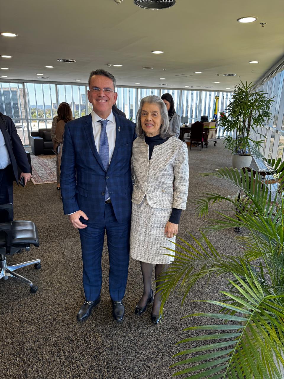 A imagem mostra o desembargador Claudio Mello Tavares e a ministra Cármen Lúcia em pé, um ao lado do outro, posando para a foto