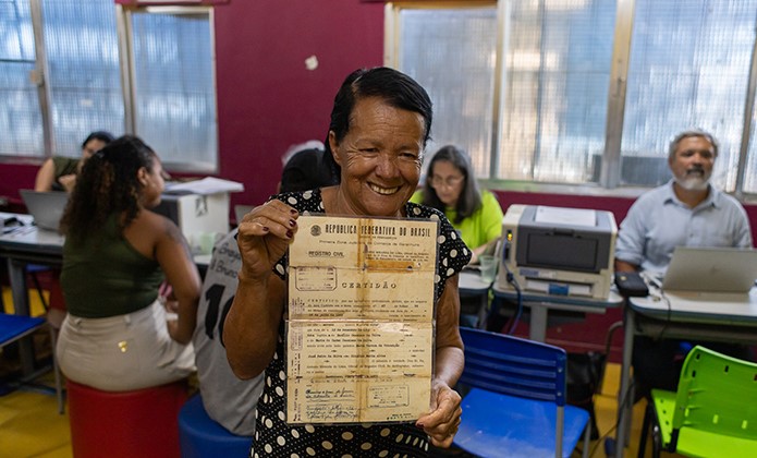 Lenilda Cassiano da Silva mostra a certidão de casamento dos pais durante a Justiça Itinerante em Jardim Gramacho