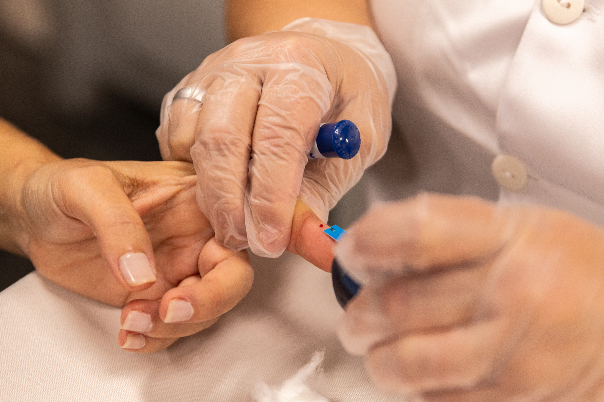 Uma técnica enfermagem realiza aferição de pressão, glicemia capilar, batimentos cardíacos e saturação das pessoas.
