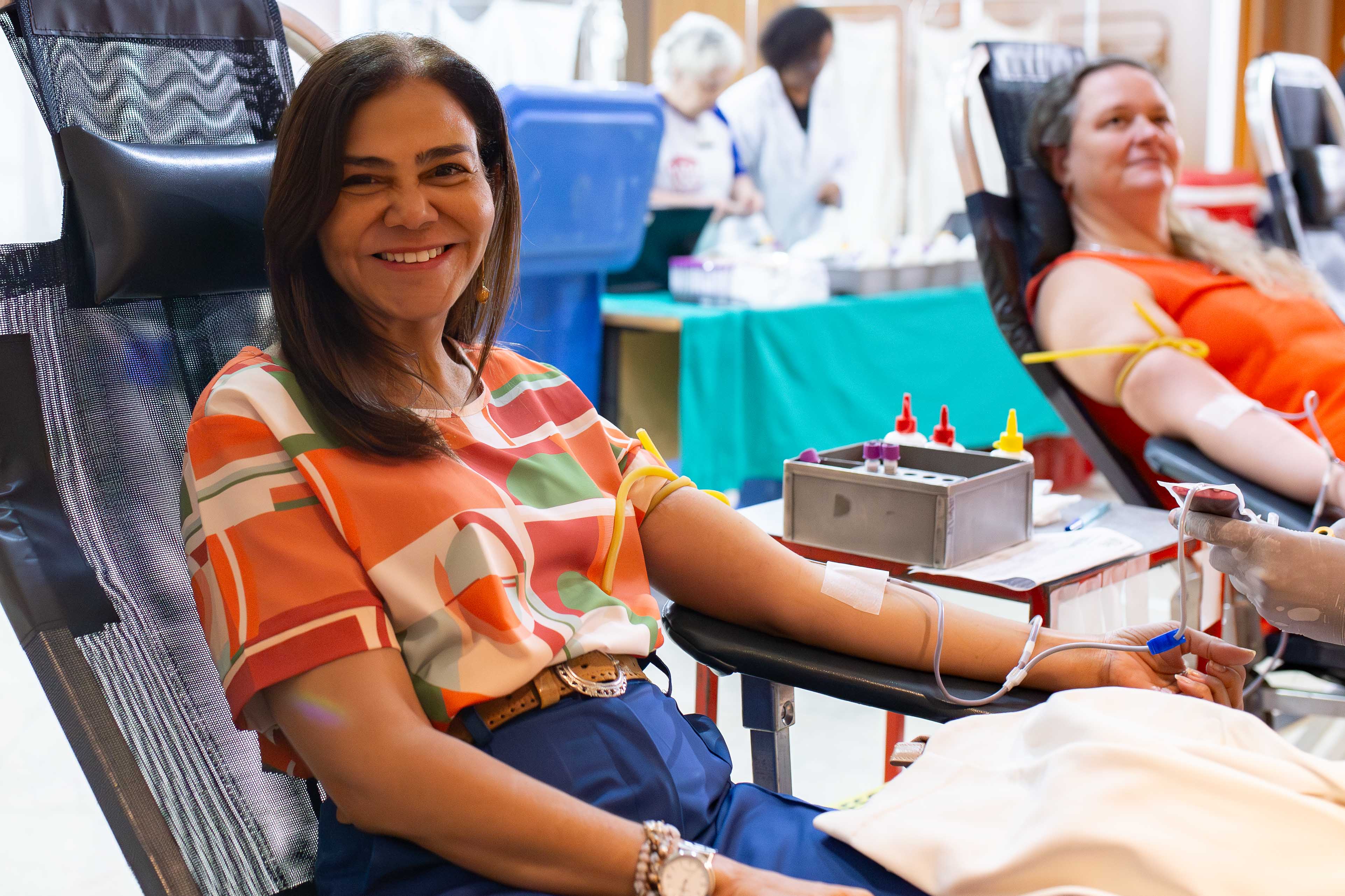 Imagem de servidora sentada doando sangue