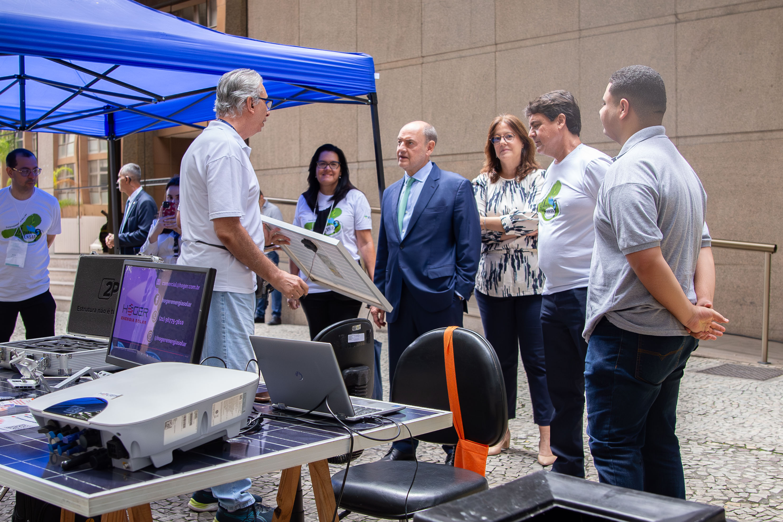 Imagem do presidente do TJRJ, desembargador Ricardo Couto de Castro, visitando a exposição na parte externa com a juíza auxiliar Paula Feteira Soares e com o secretário-geral da SGSUS, Carlos Eduardo Menezes da Costa