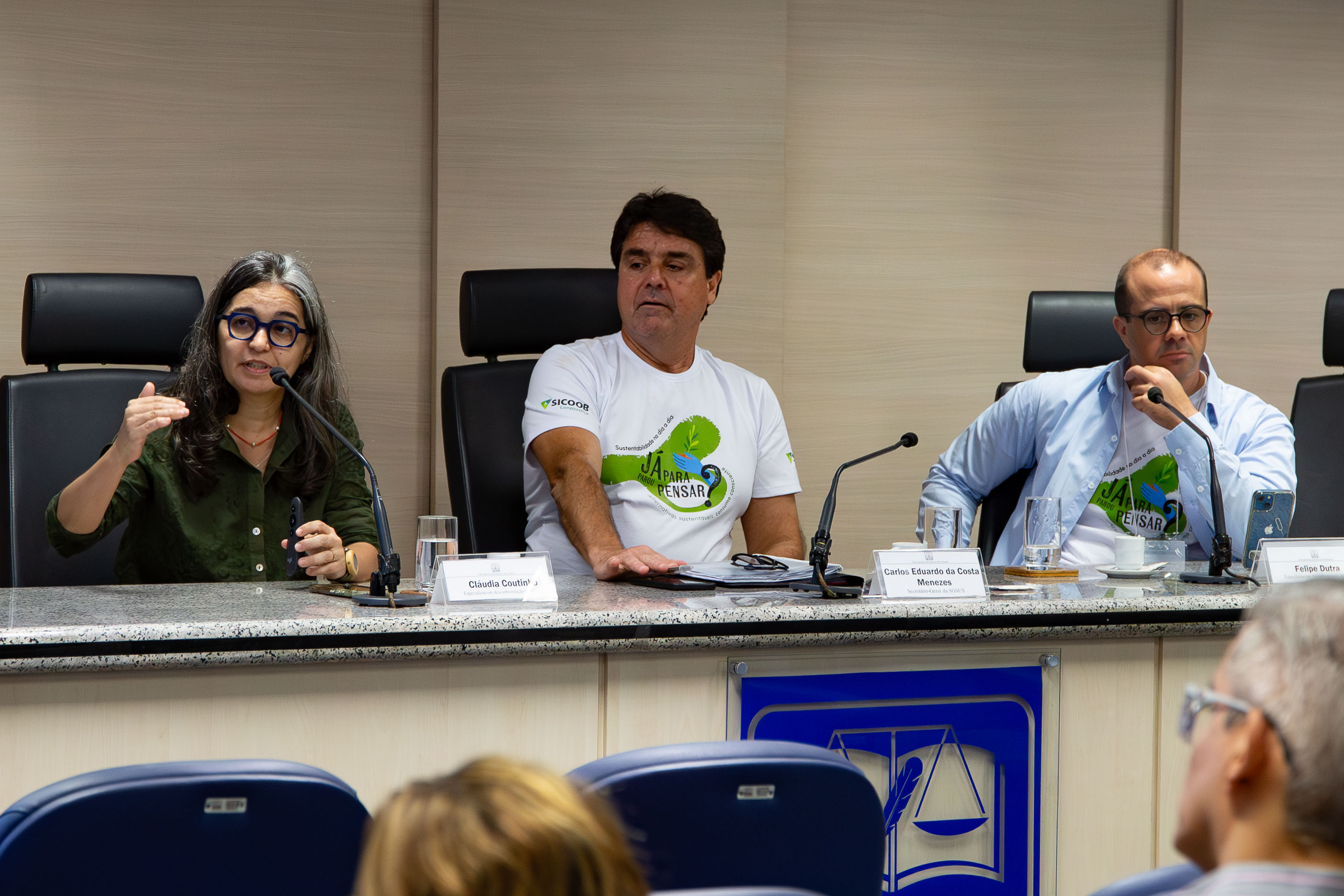 Foto da mesa. Da esquerda para a direita: a especialista em descarbonização Cláudia Coutinho; secretário-Geral da SGSUS, Carlos Eduardo da Costa Menezes; e o especialista em descarbonização (SGSUS) Felipe Dutra