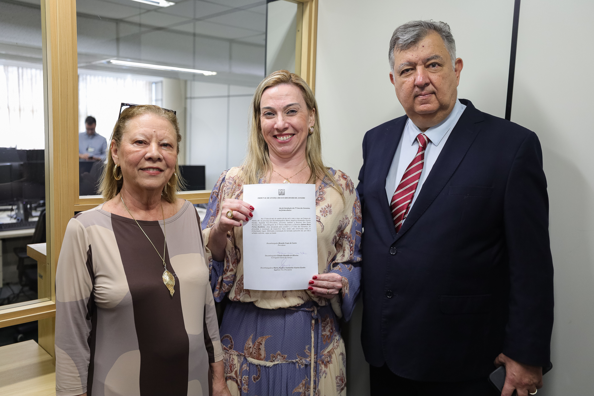 Foto posada. Da esquerda para direita: 2ª vice-presidente do TJRJ, desembargadora Maria Angélica Guimarães Guerra Guedes; juíza Juliana Bessa Ferraz Krykhtine, designada para a 2ª Vara de Garantias; e corregedor-geral da Justiça do Estado do Rio de Janeiro, desembargador Cláudio Brandão de Oliveira