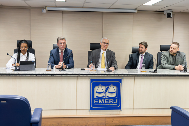 Imagem da mesa do evento. Da esquerda para direita: Da esquerda para a direita: a coordenadora do Napjus, Inara Firmino, o secretário-geral da SGPES, Gabriel Albuquerque Pinto, o desembargador Wagner Cinelli, o secretário-geral da SGDAI, Rodrigo de Oliveira Rocha e o diretor do Deige, George Gonzaga de Lima Silva&nbsp;