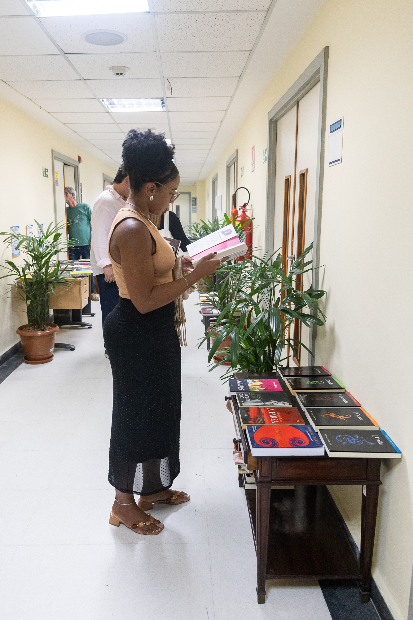 Mulher negra no corredor do Museu da Justiça lendo um livro