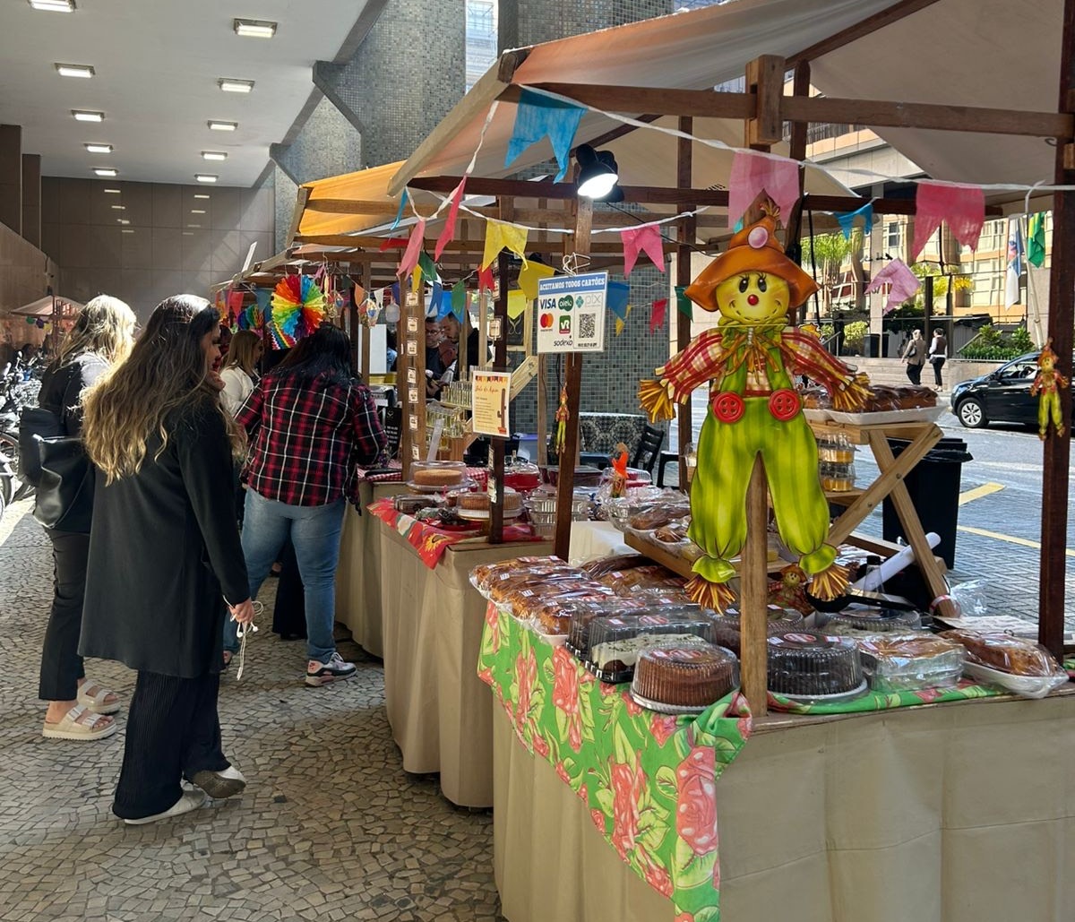 Imagem do público vendo as barraquinhas montadas na parte externa do Fórum Central
