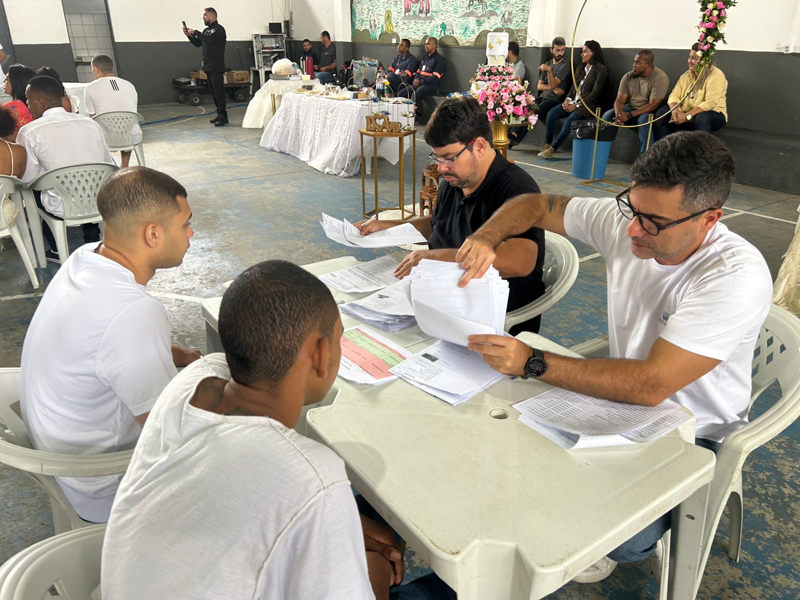 Imagem de atendimento sendo realizado pela equipe da Justiça Itinerante a dois presos 