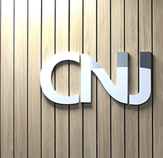 Logo do CNJ em destaque, sobre fundo de madeira clara.