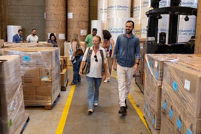 Uma foto da desembargadora Maria Angélica, 2a Vice-Presidente do Tribunal de Justiça do Estado do Rio de Janeiro (TJRJ) conhecendo o trabalho nos setores da gráfica, logística e produção da Editora Record.