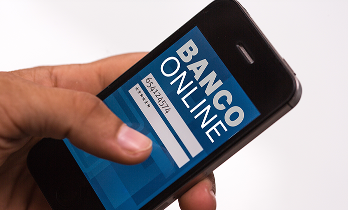 #ParaTodosVerem: Mão segurando um smartphone com tela exibindo página de acesso a banco online, com campos para número e senha.